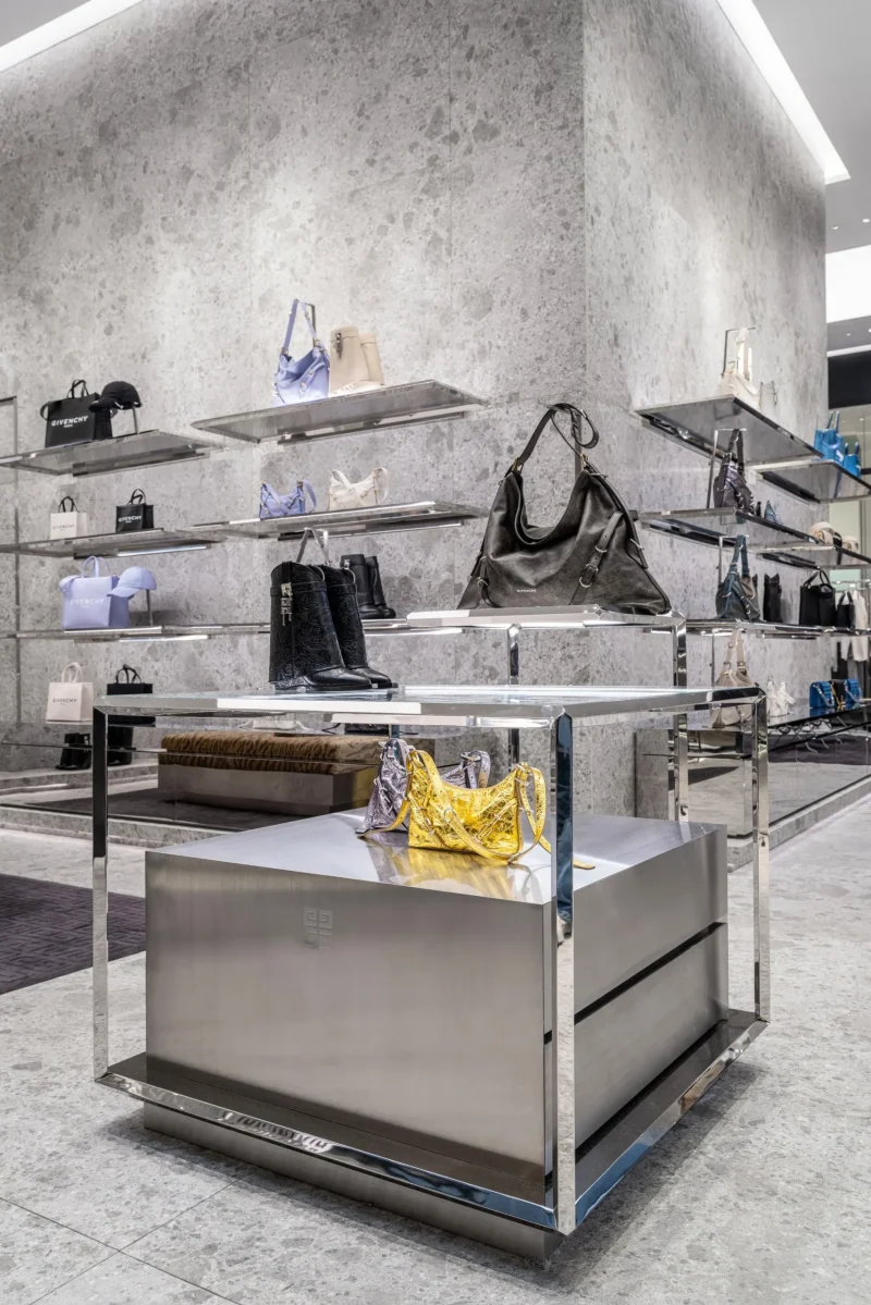 Mirrored display table with boots, handbags, and mini bags at Givenchy Siam Paragon boutique