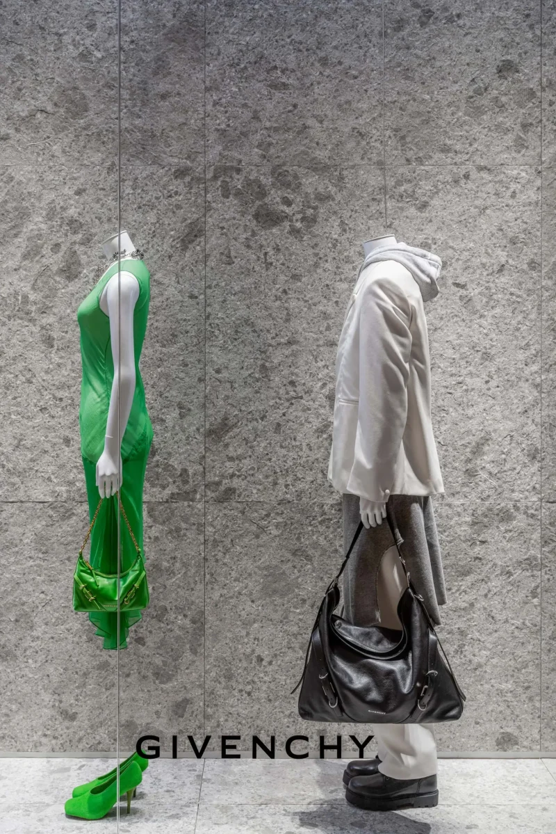Headless mannequins in green dress and grey coat display at Givenchy Siam Paragon window