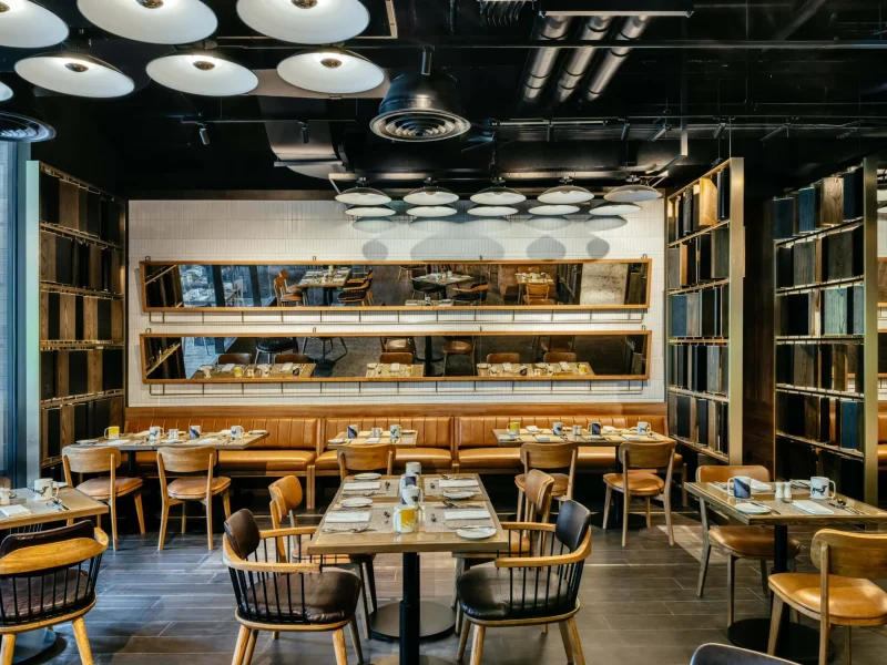 Deckles restaurant dining room at voco Surawong, with leather banquettes and industrial pendant lighting