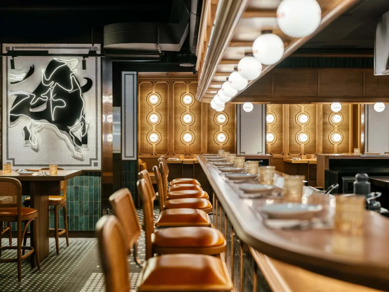 Tasca Sabio restaurant bar at voco Surawong, with neon bull artwork and globe pendant lighting