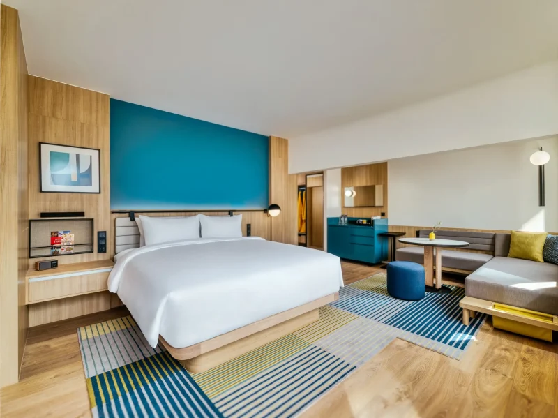 voco Surawong grand king room with teal accent wall, seating area, and amenities