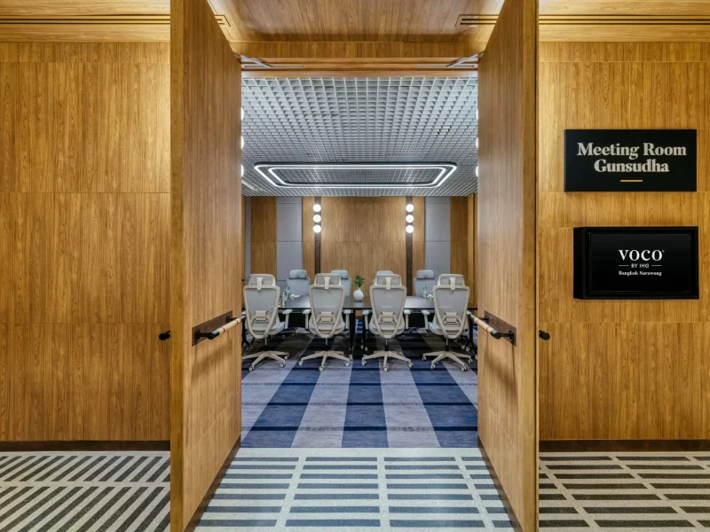Gunsudha meeting room at voco Surawong with conference table, ergonomic chairs, and coffered ceiling