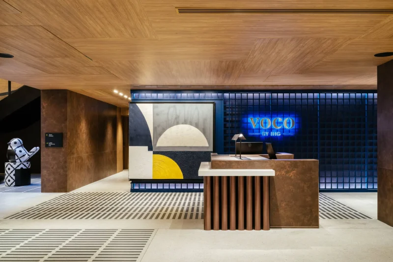 voco Surawong front desk with neon signage, patterned bird sculptures, and abstract wall art
