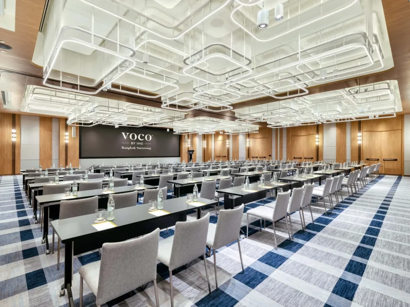 Full voco Surawong ballroom set classroom-style with screen, branded backdrop, and sculptural ceiling lighting