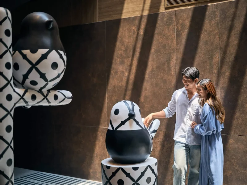 Hotel photographer Bangkok — couple admiring bird art installation at voco Surawong